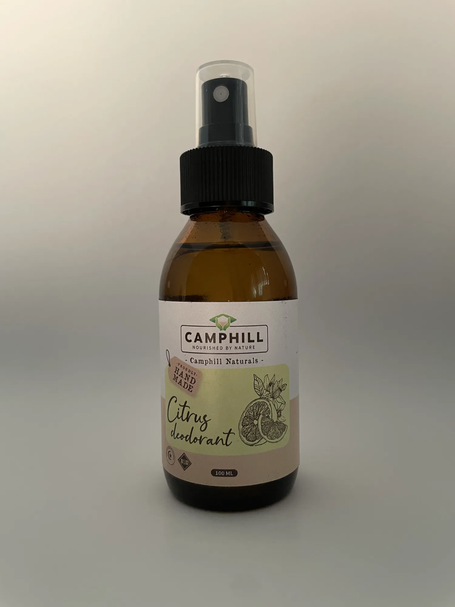 A 100ml amber glass spray bottle of Camphill Citrus Deodorant, labelled Camphill Naturals and proudly hand made