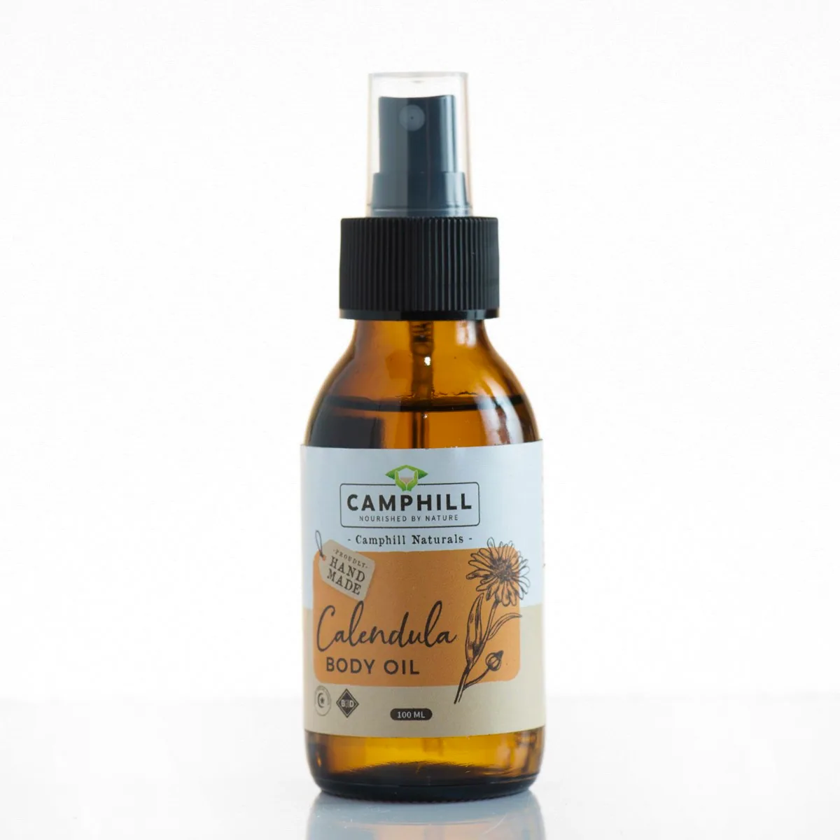 Amber glass pump bottle of Camphill Naturals calendula body oil
