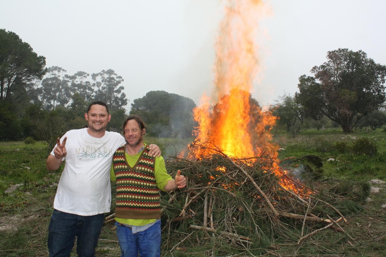 2 residents in front of a burn pile